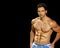Male fitness model on black background