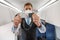 Male flight attendant in safety face mask holding seatbelt