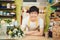 Male florist in flower shop. Man in apron is cutting stems and preparing roses for a bouquet. Owner of the flower shop, doing