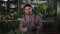 Male florist holding cactus and looking at camera