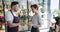 Male florist holding green plant talking to female customer in flower store