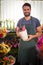 Male florist holding pot plant at his flower shop