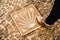 Male foot stepping on  a brown tile with a scallop shell symbol in a cobblestone street