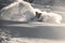 Male freerider with face covered in snow slipping on snowy mountain