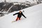 Male freerider glides down the mountain slope