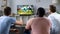 Male friends gather to watch football competition on big screen, sofa experts