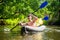 Male friends swim in kayak on wild river in summer