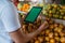 male fruit seller holding the digital tablet while checking the passion fruit