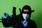 Male gangster or criminal in a medical surgical mask and sunglasses dressed in black clothes