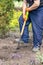 Male gardener with a shovel digging ground in on a backyard, a garden bed or a farm. Worker digs soil with shovel