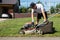 Male gardener unscrews the plastic fuel tank cap for a gasoline refueling lawn mower.