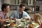 Male gay couple and daughter dining in their kitchen