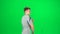 Male goes and dances, smiles and rejoices on a green screen, Chroma Key. Side view