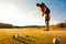 Male golf player practicing a par during sunset