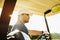 Male golfer driving a golf cart