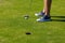 Male golfer feet next to hole