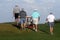 Male golfers on putting green.