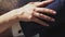 Male groom gently holds the hand on the shoulder of his bride in a white wedding dress. Slow motion. Close-up