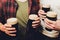 Male group clinking glasses of dark and light beer on brick wall background.