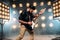 Male guitarist on stage with decorations of lights