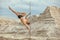 Male gymnast does tricks on a pylon.