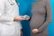 Male gynecologist giving pills to pregnant woman during appointment at colored background. Visit To A Doctor Pregnancy Healthcare