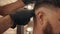 Male haircut with electric shaver close up. Hands hairdresser using hair trimmer for cutting hair to bearded man. Hair