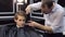 Male hairdresser cuts a young boy in a barbershop.