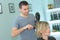 Male hairdresser drying womans hair after haircut