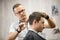 Male hairdresser making haircut