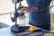 Male hairy hands make freshly squeezed orange juice at a beach cafe by the sea