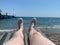 Male hairy legs of a vacationer on a sun lounger on the beach at the sea