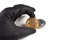 Male hand in black glove holds bitcoin isolated on white. Crime and cryptocurrency concept.