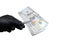 Male hand in black glove holds a pack of US dollars with tweezers. Object for the design of the concept of violation of the law,