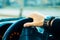 Male hand with bracelet and watch driving a car