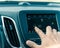 Male hand changing the radio station on car LCD infotainment screen