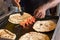 Male hand of a cook, cooking prawns with pol roti flat bread tn the food street market of Galle Face Dr st in Colombo, Sri Lanka