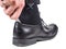 Male hand entering black sock on foot into leather shoe with shoehorn