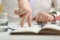 Male hand fingers walking on white table with book