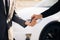 Male hand gives a car keys to male hand in the car dealership close up. Unrecognized auto seller and a man who bought a