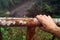 Male hand gripping to a rusty river bridge fence