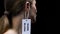 Male hand hanging dumb blond label on female ear, social prejudice and sexism