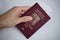Male hand holding back of Czech passport as a symbol of international traveling and personal identification of European citiz