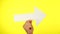 Male hand holding a big white arrow pointing right isolated on yellow background