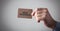 Male hand holding a brown business card. New Business