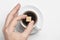 Male hand holding cane sugar cube over cup of black coffee against white background top view with space for text