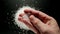 Male hand holding coarse salt in a hand, top view