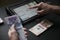 Male hand holding colombian banknotes while he does the math on a tablet