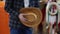 The male hand is holding a cowboy hat in hats store. Close up of handmade cowboy hat in shop of the Texas