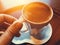 Male hand holding delicious hot sahlep with cinnamon served with porcelain cup